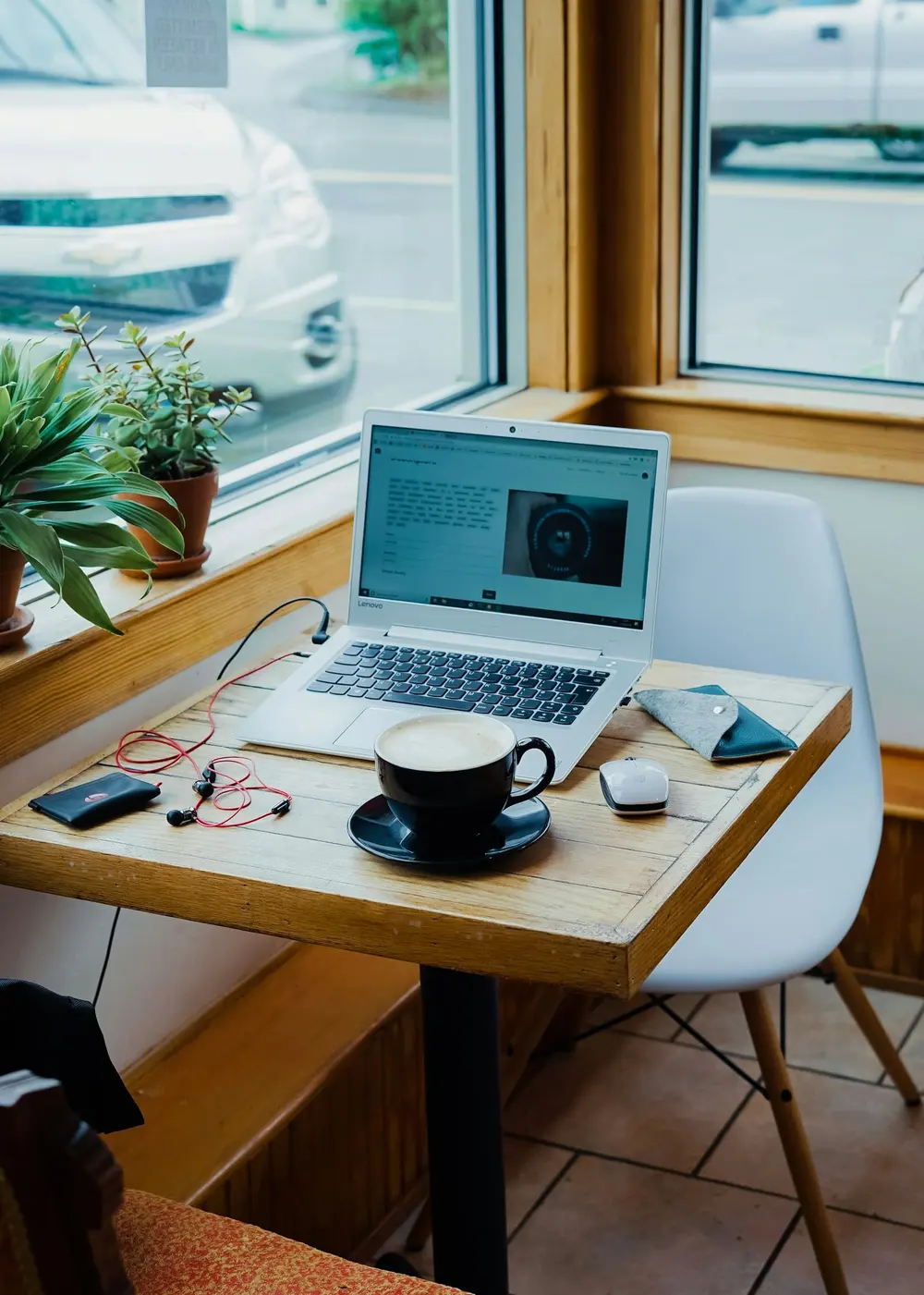 Laptop en koffie op een tafel bij het raam