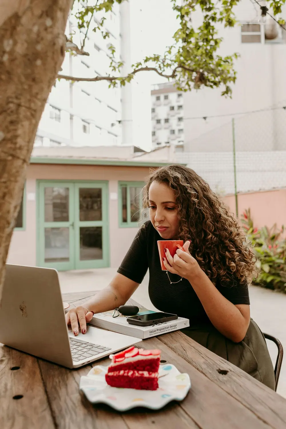 Ondernemer drinkt koffie en werkt op haar laptop